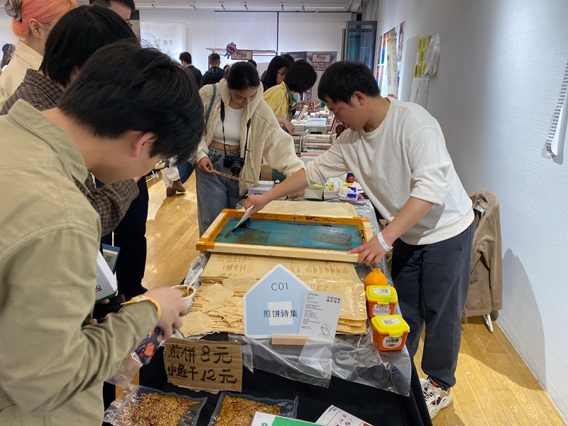 来自山东的“煎饼诗人”在煎饼上印诗歌    摄影/佟鑫